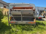 un camion garé dans l'herbe près d'un bâtiment