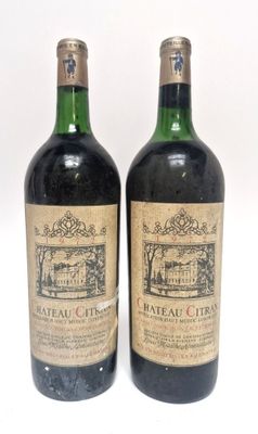 deux bouteilles de vin sont posées l'une à côté de l'autre sur une surface blanche