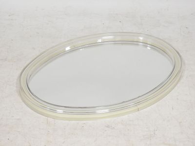 un petit miroir ovale posé sur une table, sur fond blanc