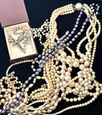 un gros plan d'un collier orné de perles et d'une croix