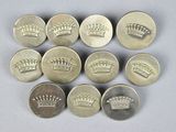six silver buttons with crowns on them on a white surface