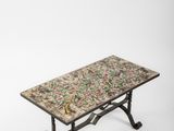 une petite table sur laquelle est posé un oiseau, sur fond blanc