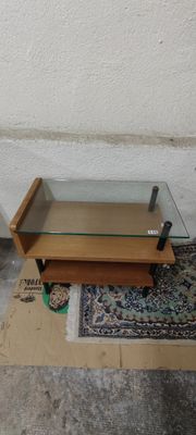une table basse en verre surmontée d'une étagère en bois
