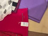 many different types of scarves laid out on a table