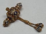 une broche en or ornée de pierres bleues et blanches