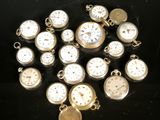 many different types of pocket watches on a black surface