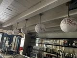several white paper lanterns hanging from the ceiling of a restaurant