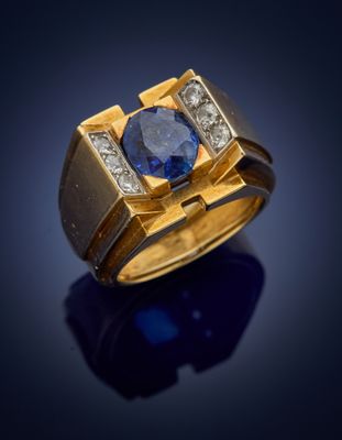 a close up of a gold ring with a blue sapphire and diamonds