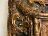 a mirror with a gold frame with a lion on it