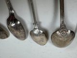 five spoons that are lined up on a table