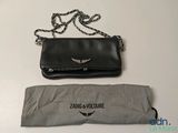 un sac à main noir et un parapluie posés sur une table