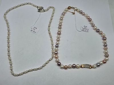 two necklaces with pearls and a gold clasp on a white surface