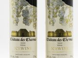 two bottles of wine sitting next to each other on a white surface