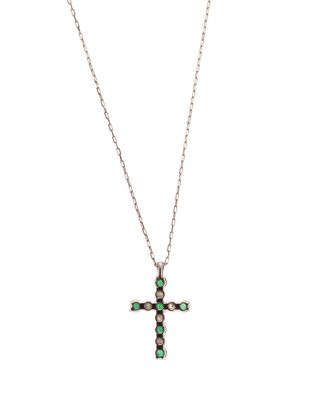un petit collier avec une croix ornée de pierres vertes et blanches, monté sur une chaîne
