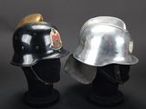 pair of firemen ' s helmets on display against a black background