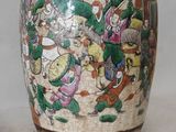 a vase with a painting on it sitting on a table