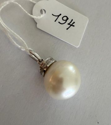un collier de perles blanches auquel est attachée une étiquette