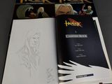 the book is open on a table next to a drawing of a man