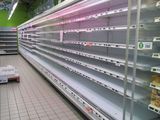 many empty shelves in a store with food in them