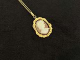 un gros plan sur un collier en or orné d'une image représentant une femme