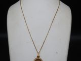 a close up of a necklace on a mannequin with a black background