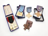 quatre médailles et une médaille dans une boîte posée sur une surface blanche