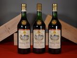 trois bouteilles de vin posées à côté d'une caisse en bois sur une table