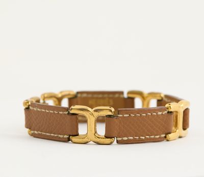 un bracelet en cuir marron avec un fermoir plaqué or