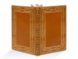 un vieux livre à la couverture brune posé sur une surface blanche