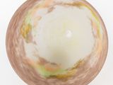 a white bowl with a yellow and green swirl inside of it