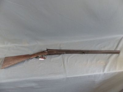 the rifle is laying on a white sheet on the floor