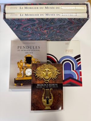 plusieurs livres posés sur une table sur laquelle se trouvent une horloge et un livre