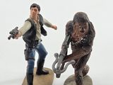figurines of a man riding a skateboard next to a statue of a gorilla