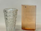 two glass vases sitting next to each other on a table