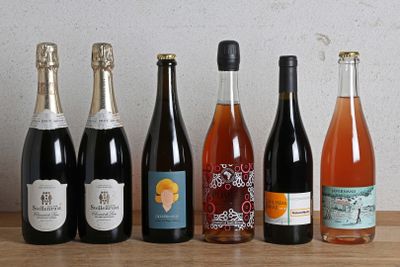 plusieurs bouteilles de vin sont alignées sur une table en bois