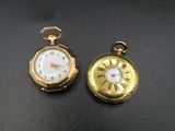 deux montres de poche dorées sur un fond noir
