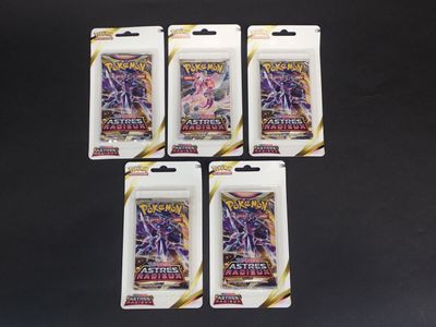 quatre paquets de cartes à collectionner Pokémon sur fond noir