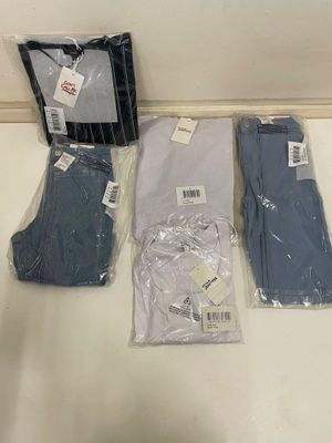 Plusieurs paires de vêtements pour hommes sont posées sur un comptoir.