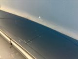 a close up of a car ' s bumper with a denting on it