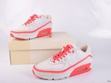 des baskets Nike Air Max blanches et roses dans une boîte, sur fond blanc