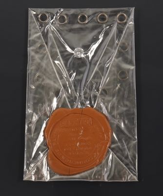 a wax seal in a plastic bag on a black surface