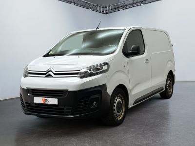 La camionnette blanche est garée dans la grande salle du bâtiment.