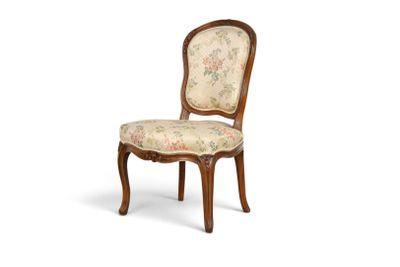 une image d'une chaise en bois dont l'assise est recouverte d'un rembourrage floral