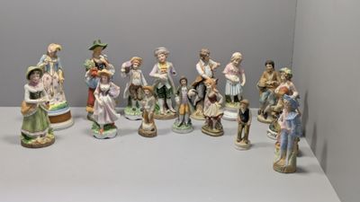 de nombreuses figurines représentant des personnes debout sur une table blanche