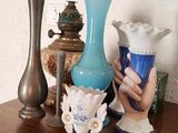 plusieurs vases posés sur une table en bois, avec un tableau en arrière-plan