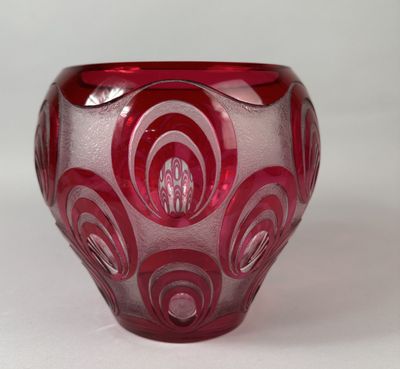 a red glass bowl with a swirl design on it