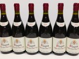 six bouteilles de vin rouge sont alignées sur une table