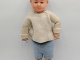 an image of a doll of a boy with a sweater and blue shorts
