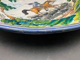 a blue and white plate with a painting of horses on it