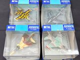quatre maquettes d'avions en plastique dans leurs boîtes, posées sur une surface noire
